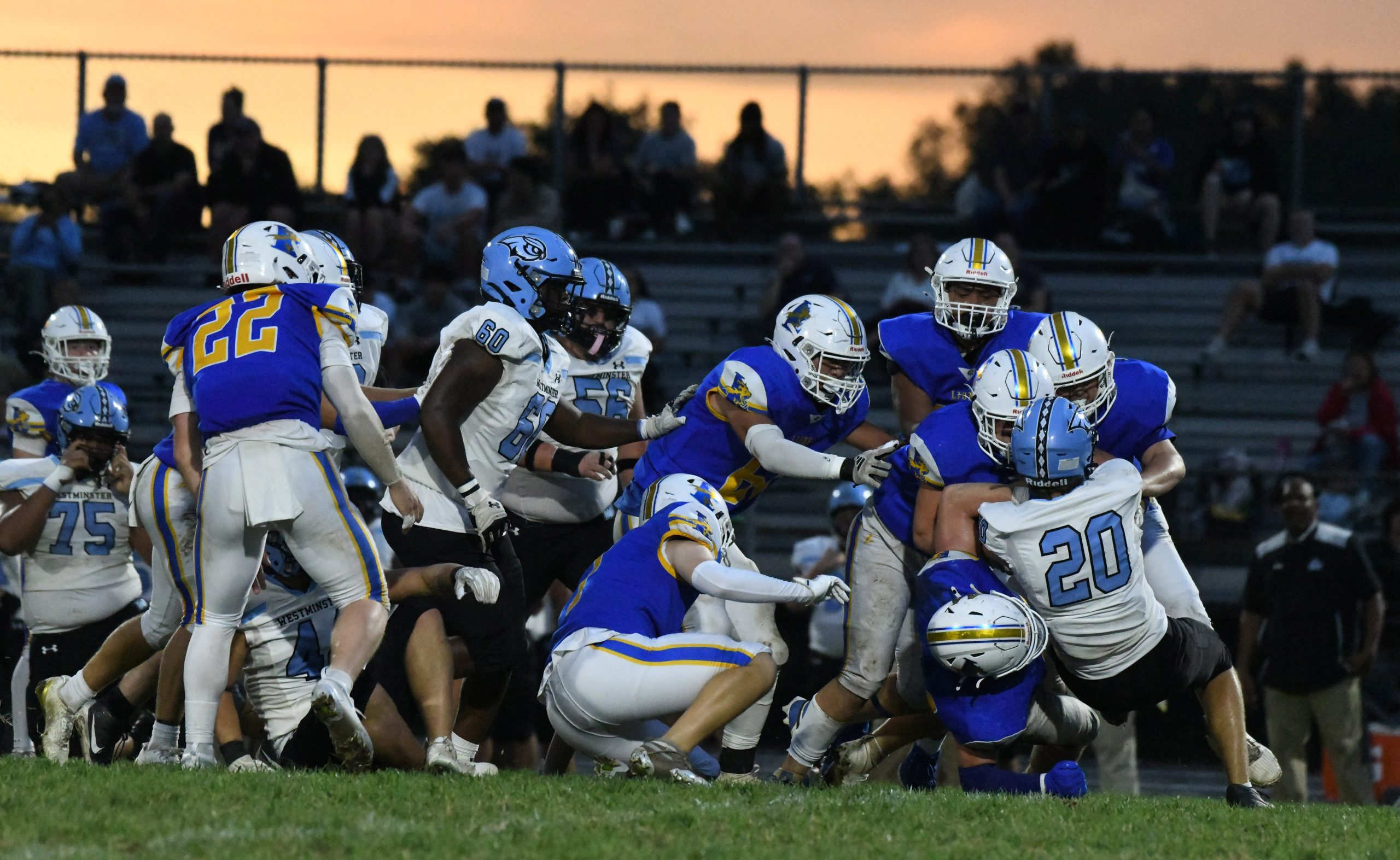 Westminster's Nick Compher #20 is tackled by a group of...