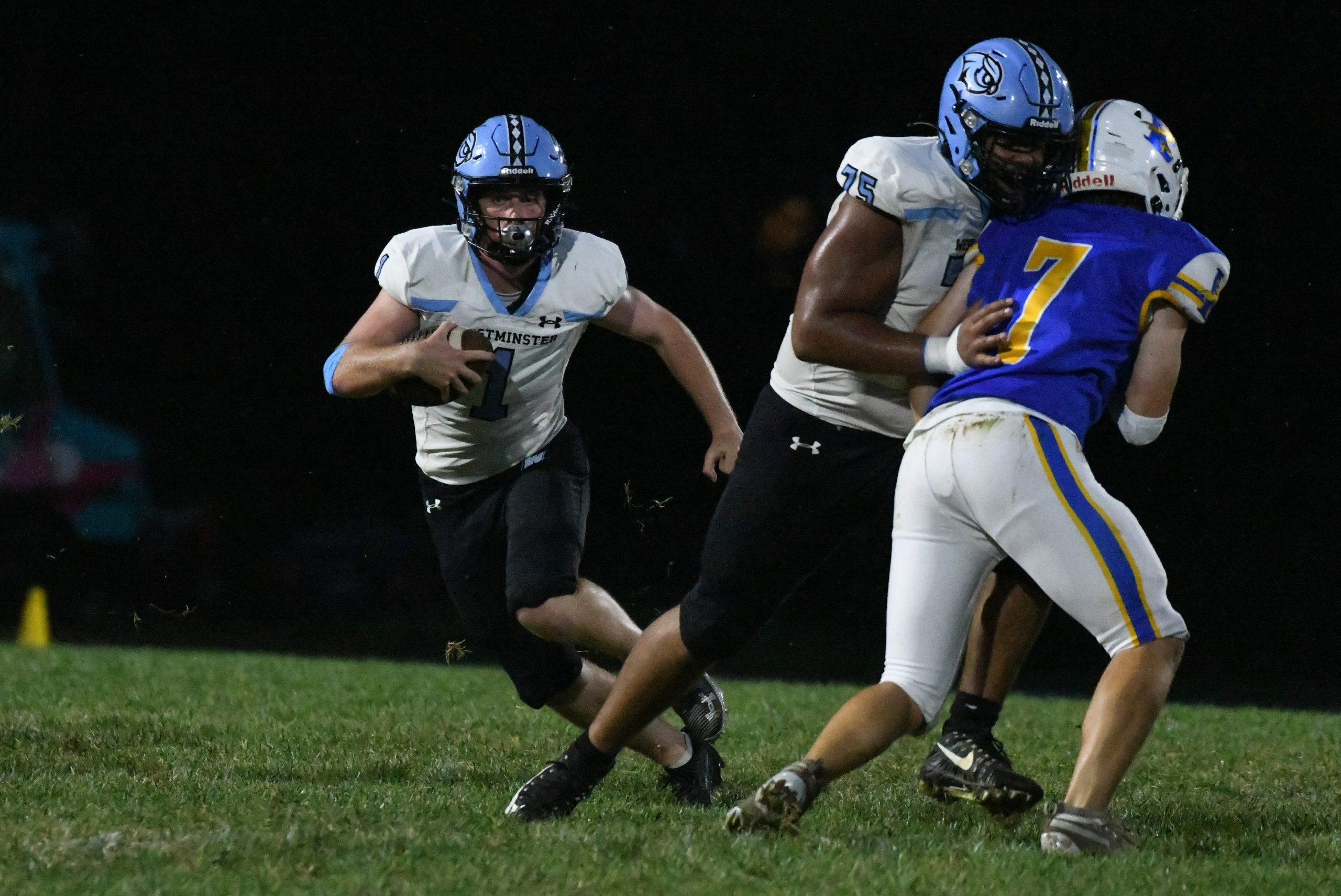 Westminster's Rory O'Connor runs behind the block of teammate David...