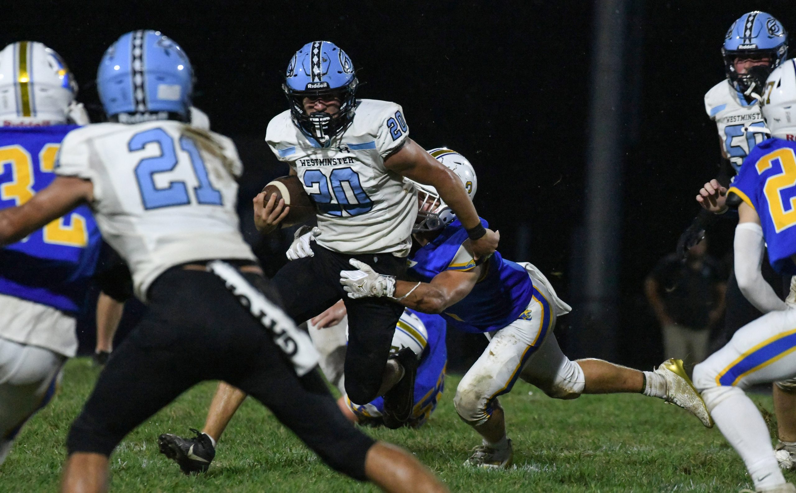 Westminster's Nick Compher tries to shed the tackle attempt of...