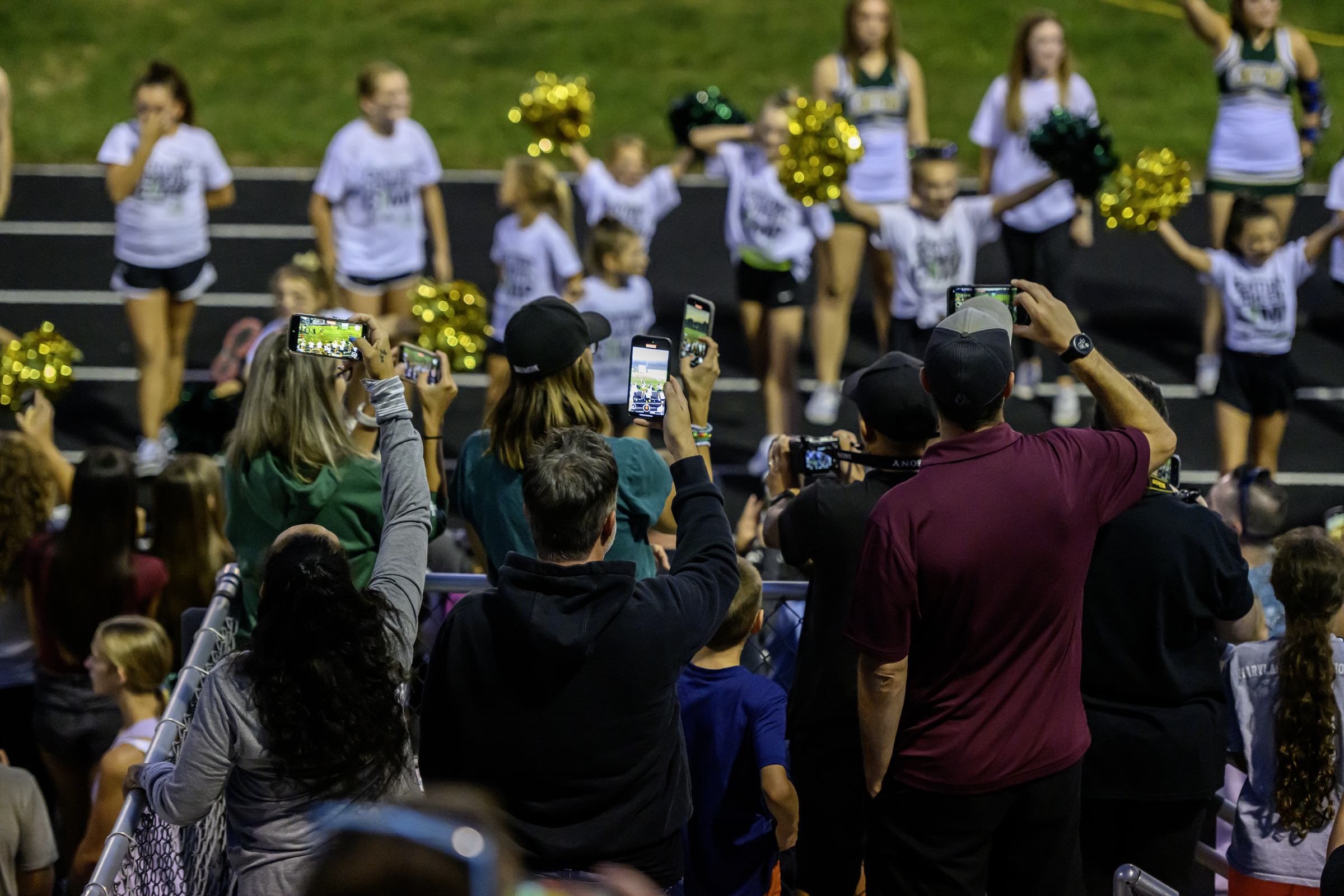 Parents record video of cheerleaders at halftime of a football...
