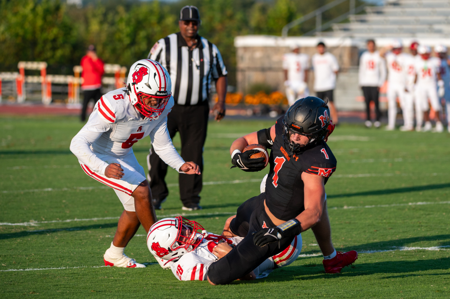 McDonogh halfback Caden Cashman stumbles with the ball after being...