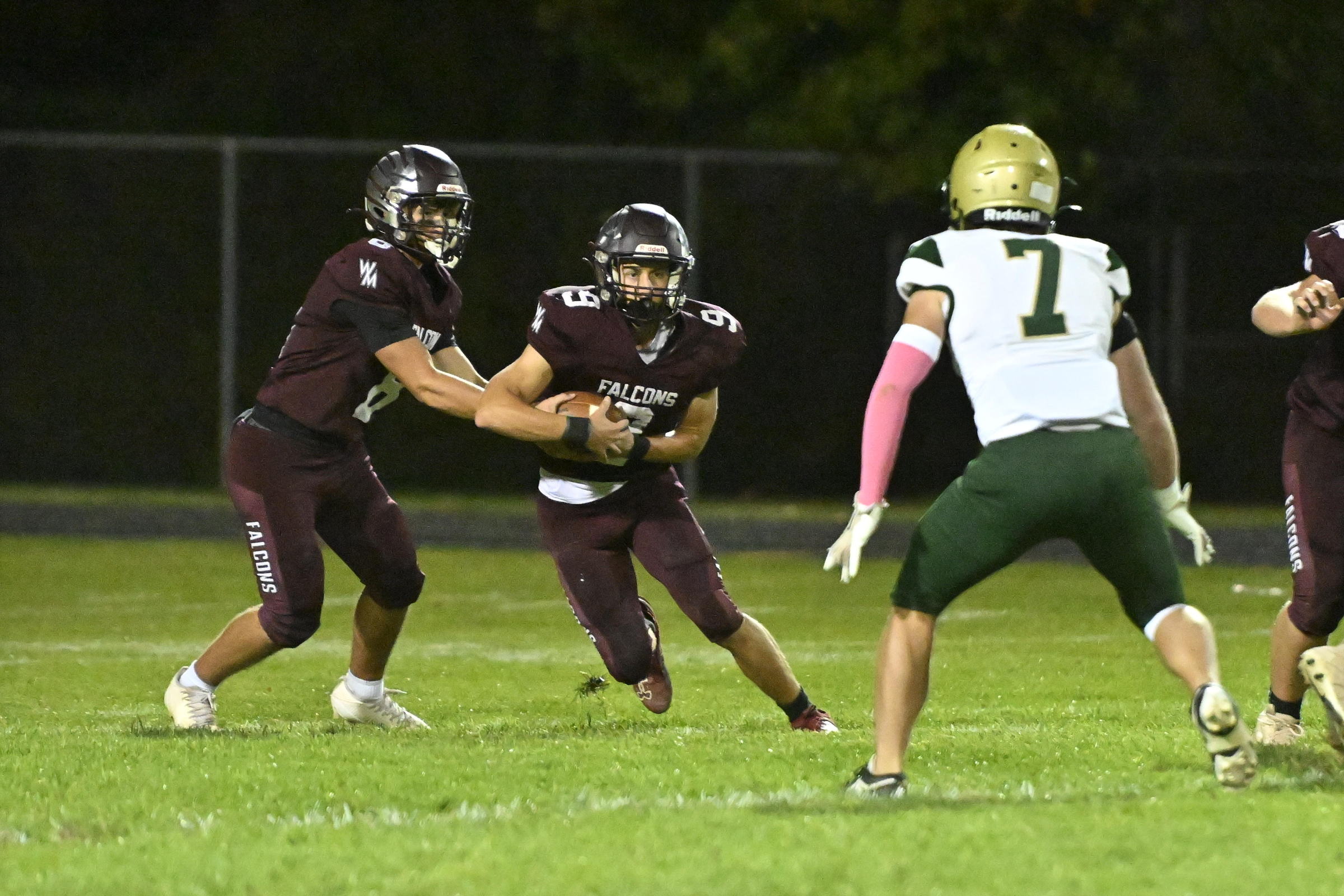 Austin Denning hands the ball off to Luke Phillips during...