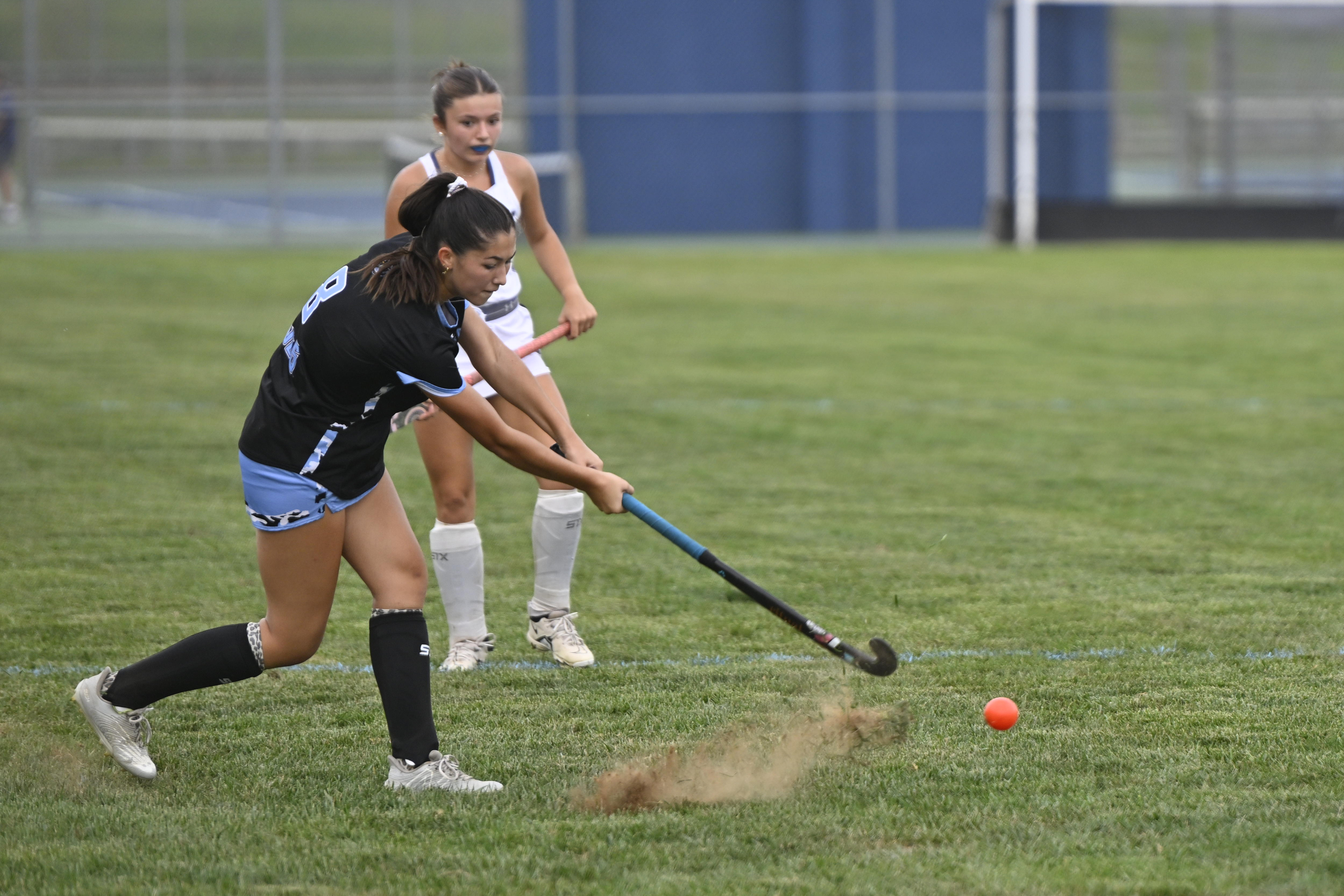 Vivian Dunn strikes the ball during a field hockey game...