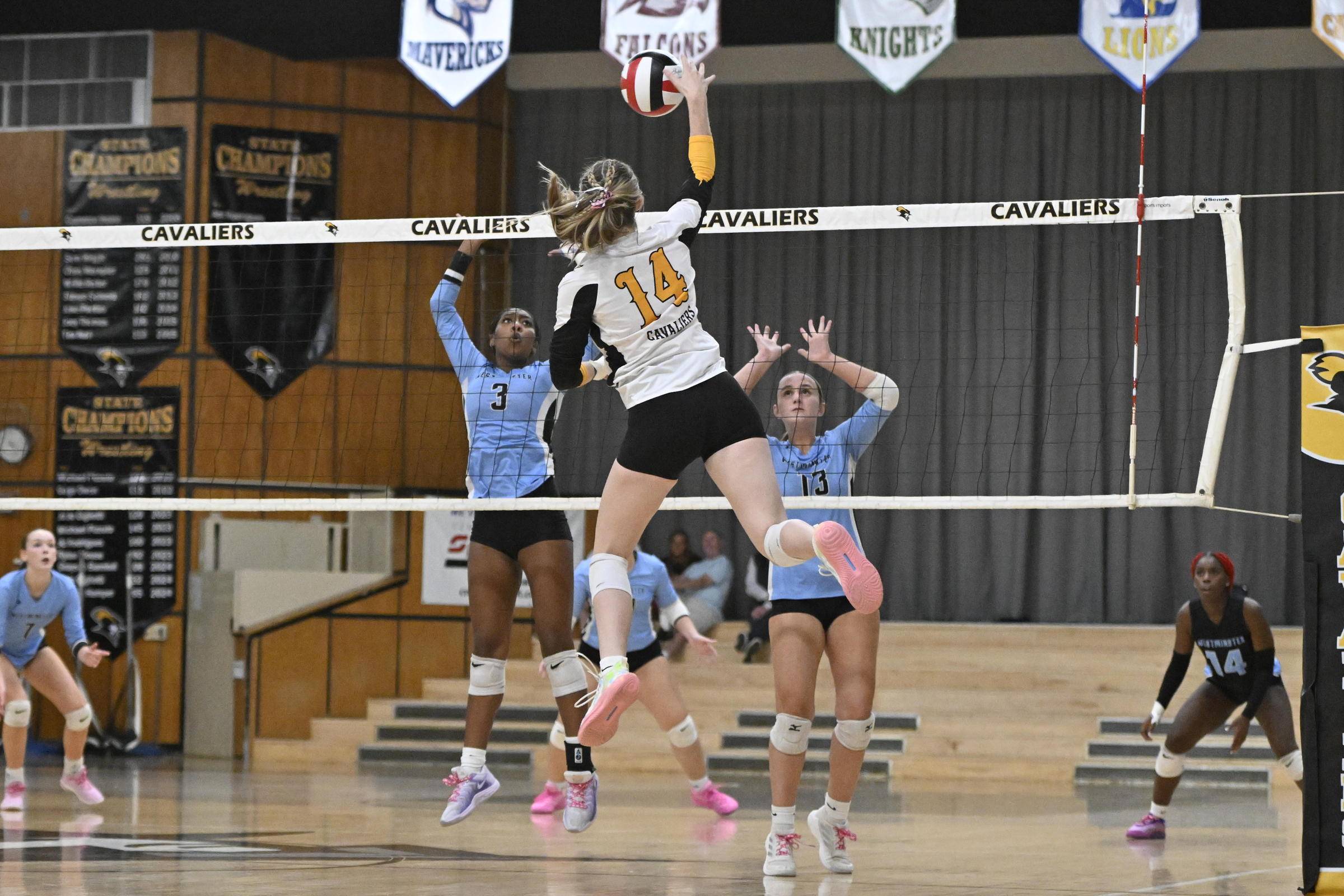 Jenna Todd spikes the ball as Westminster's Peyton Marrow, left...
