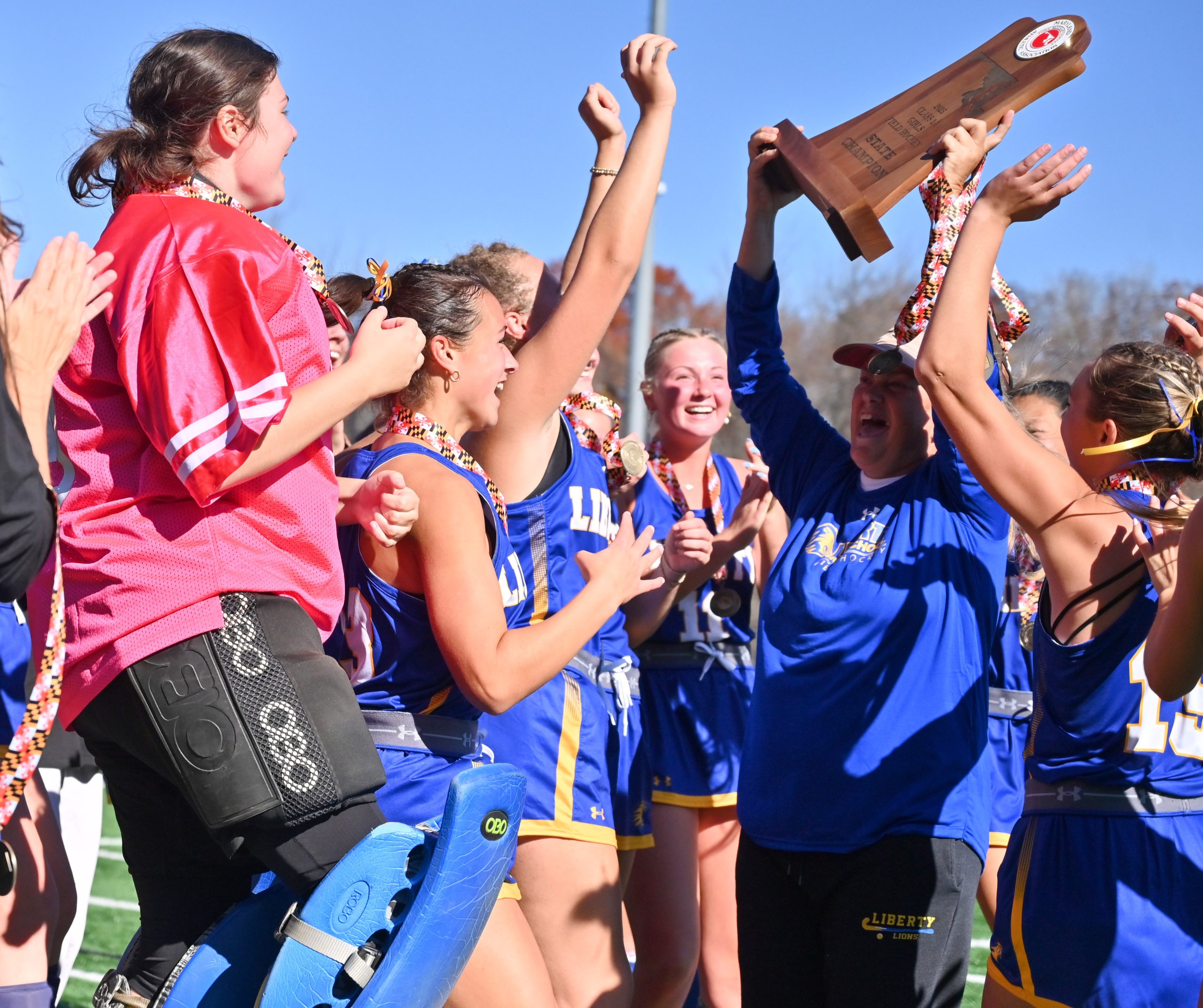 Liberty players celebrate around their coach, Brenda Strohmer, as she...