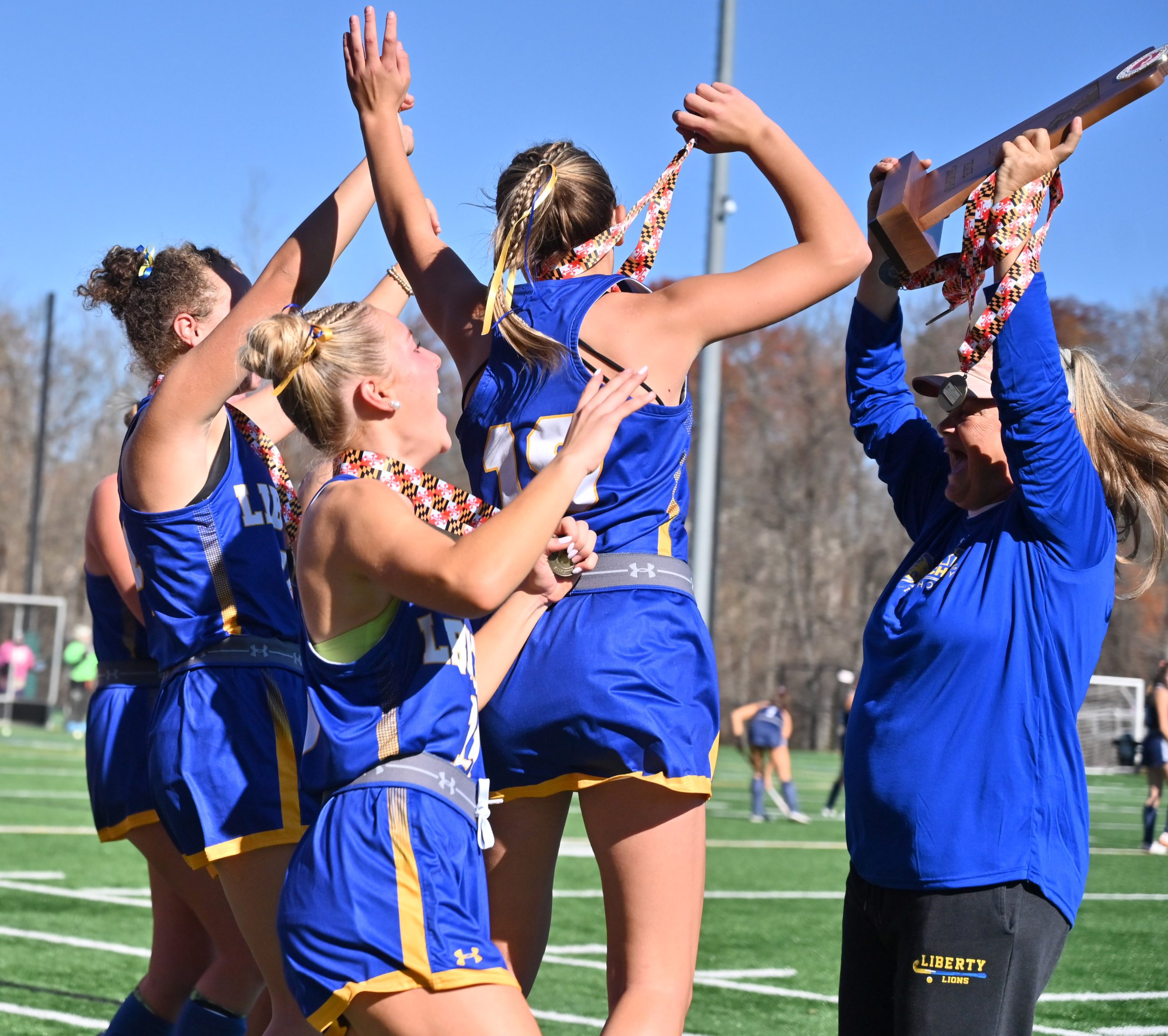Liberty players celebrate around their coach Brenda Strohmer as she...
