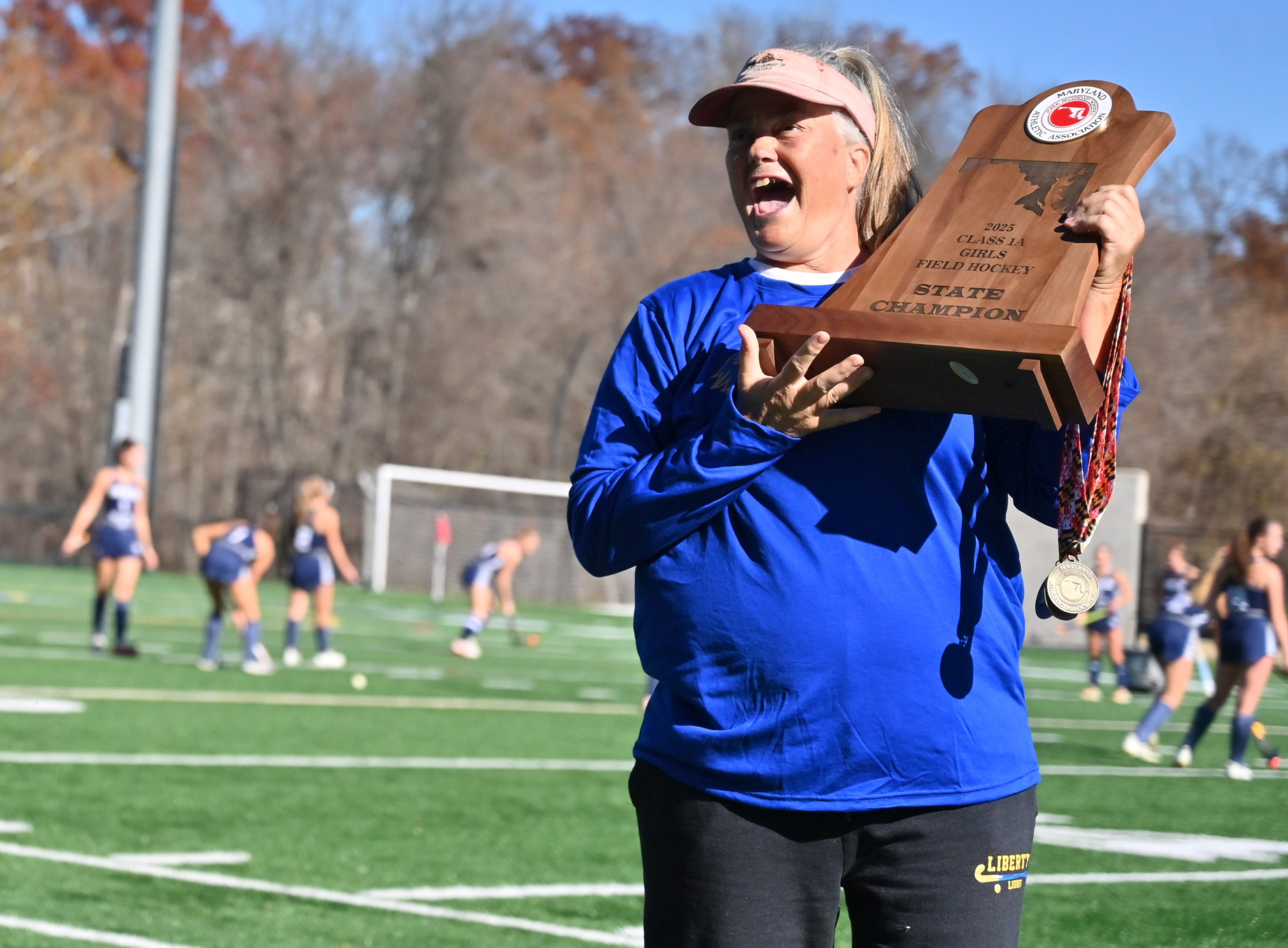 Liberty head coach Brenda Strohmer accepts the championship trophy following...