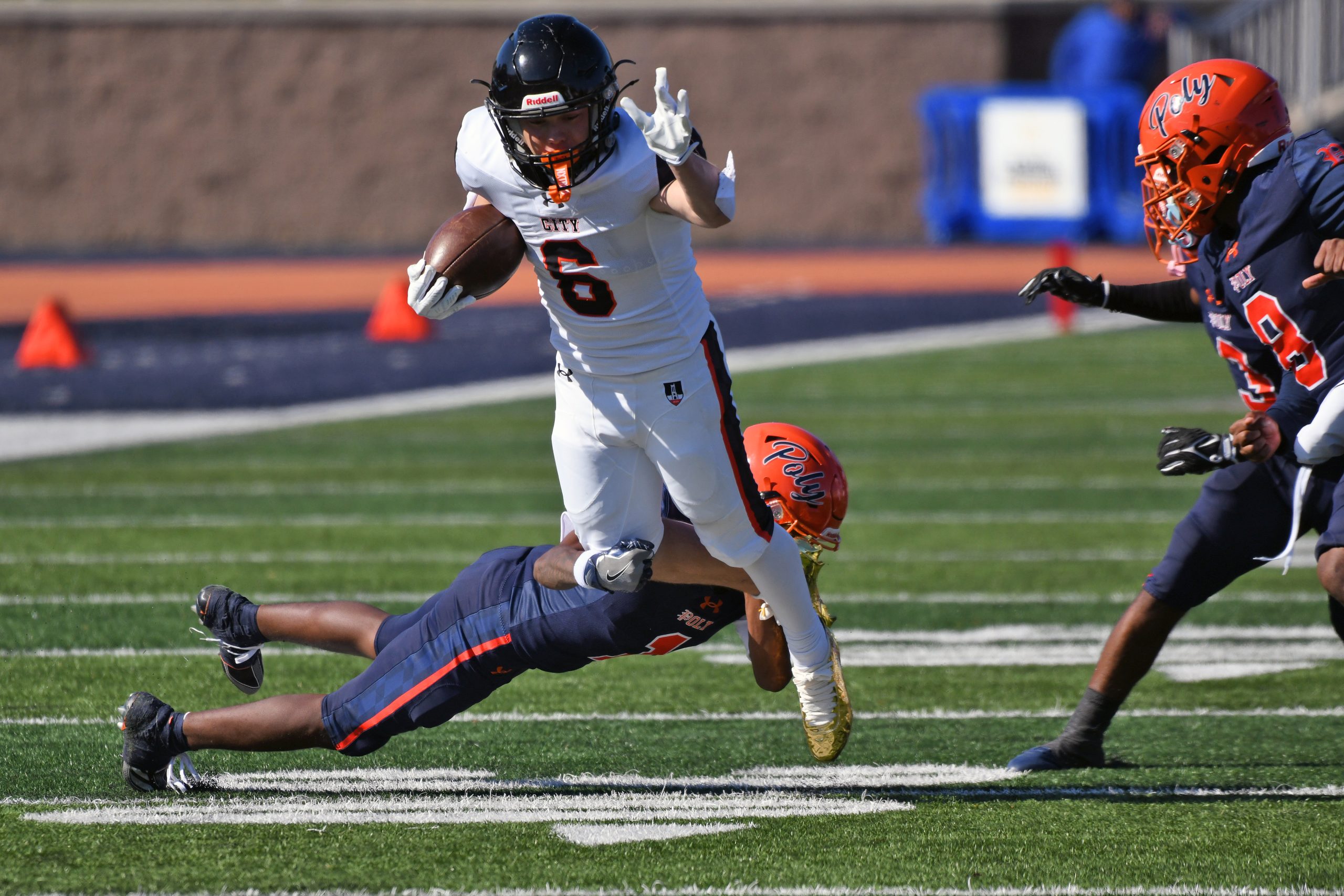City’s Ashton Holloway is tacked by Poly’s Angelo Bond in...