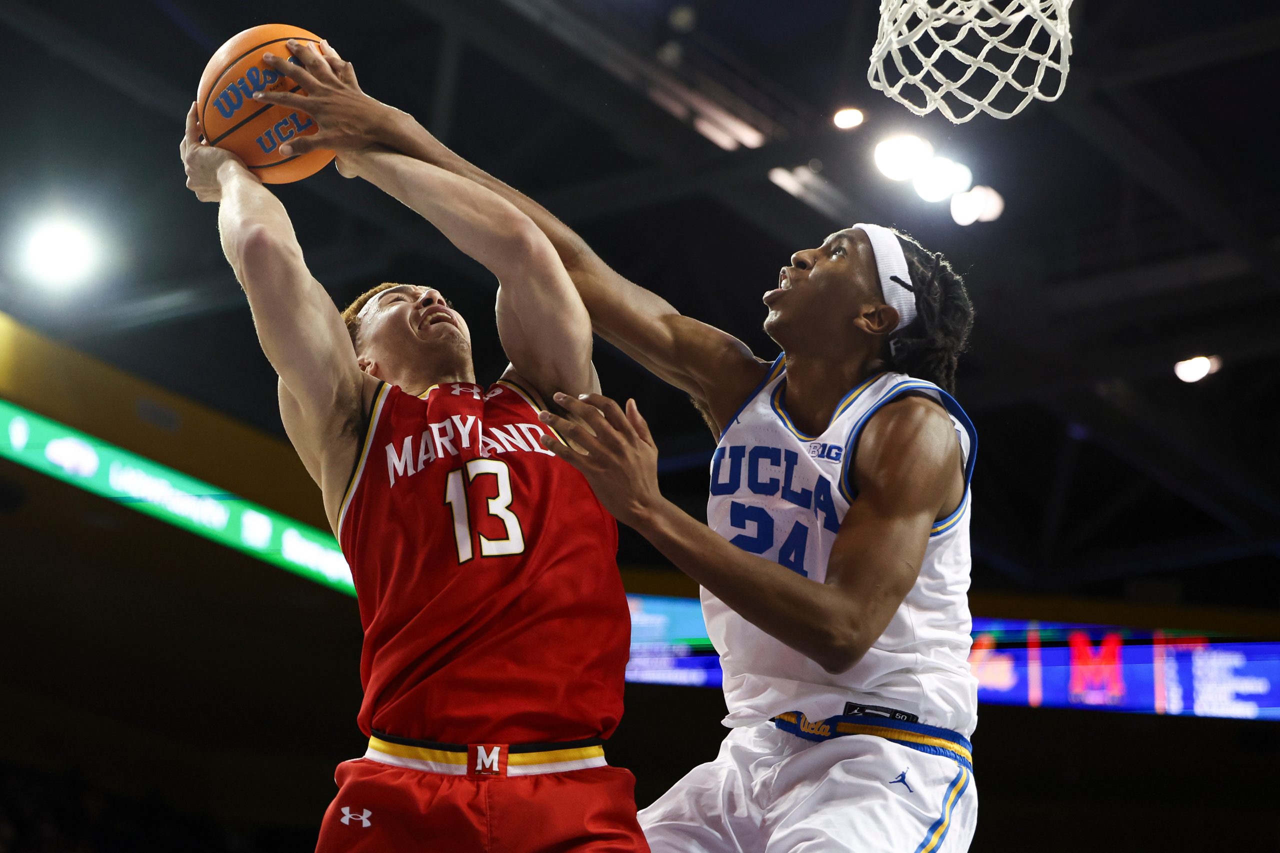 Maryland forward Elijah Saunders draws a foul against UCLA center...