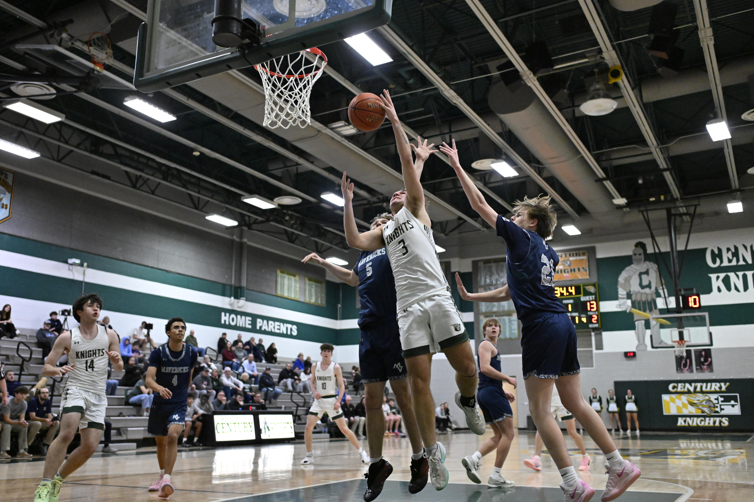 Braden Davis grabs a Century rebound during a basketball game...