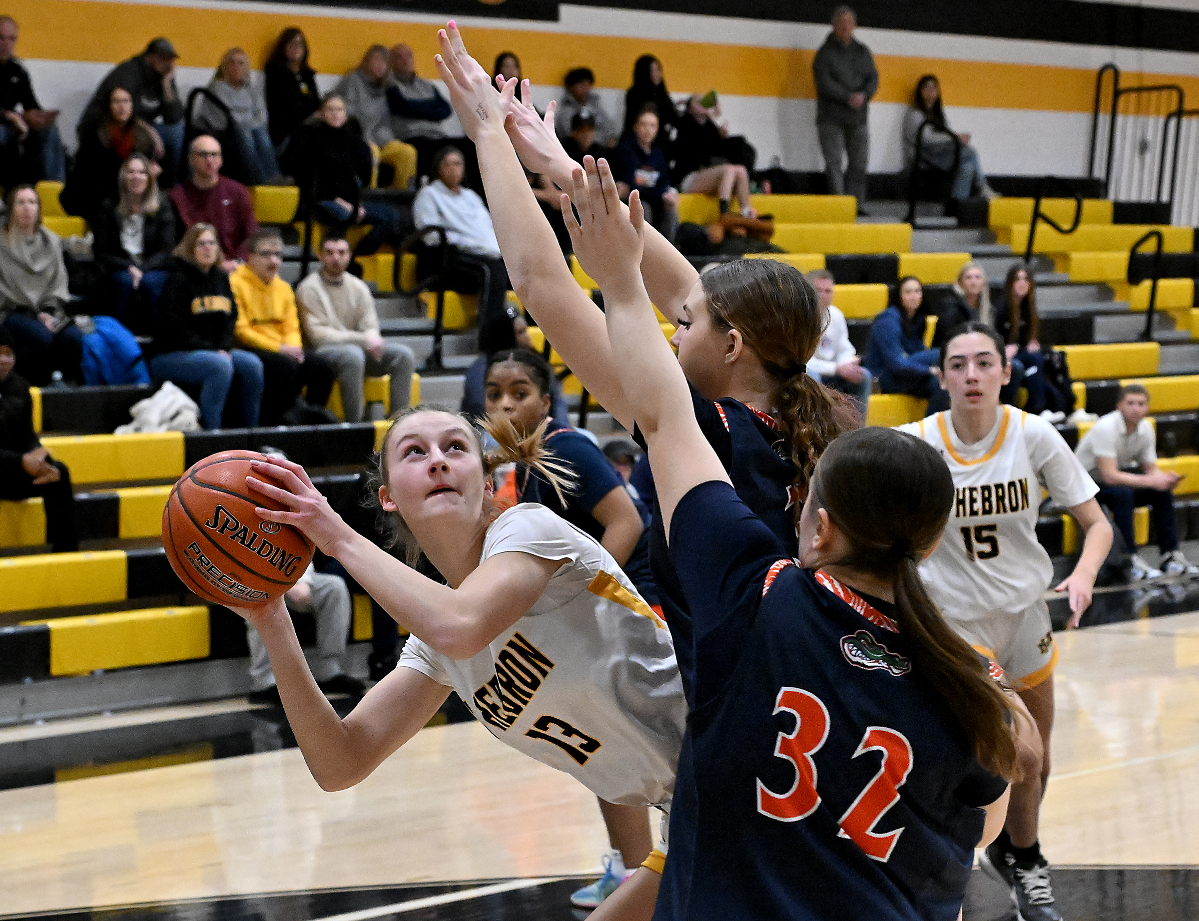Hebron #13, Veronica Jensen is double-teamed beneath the basket in...