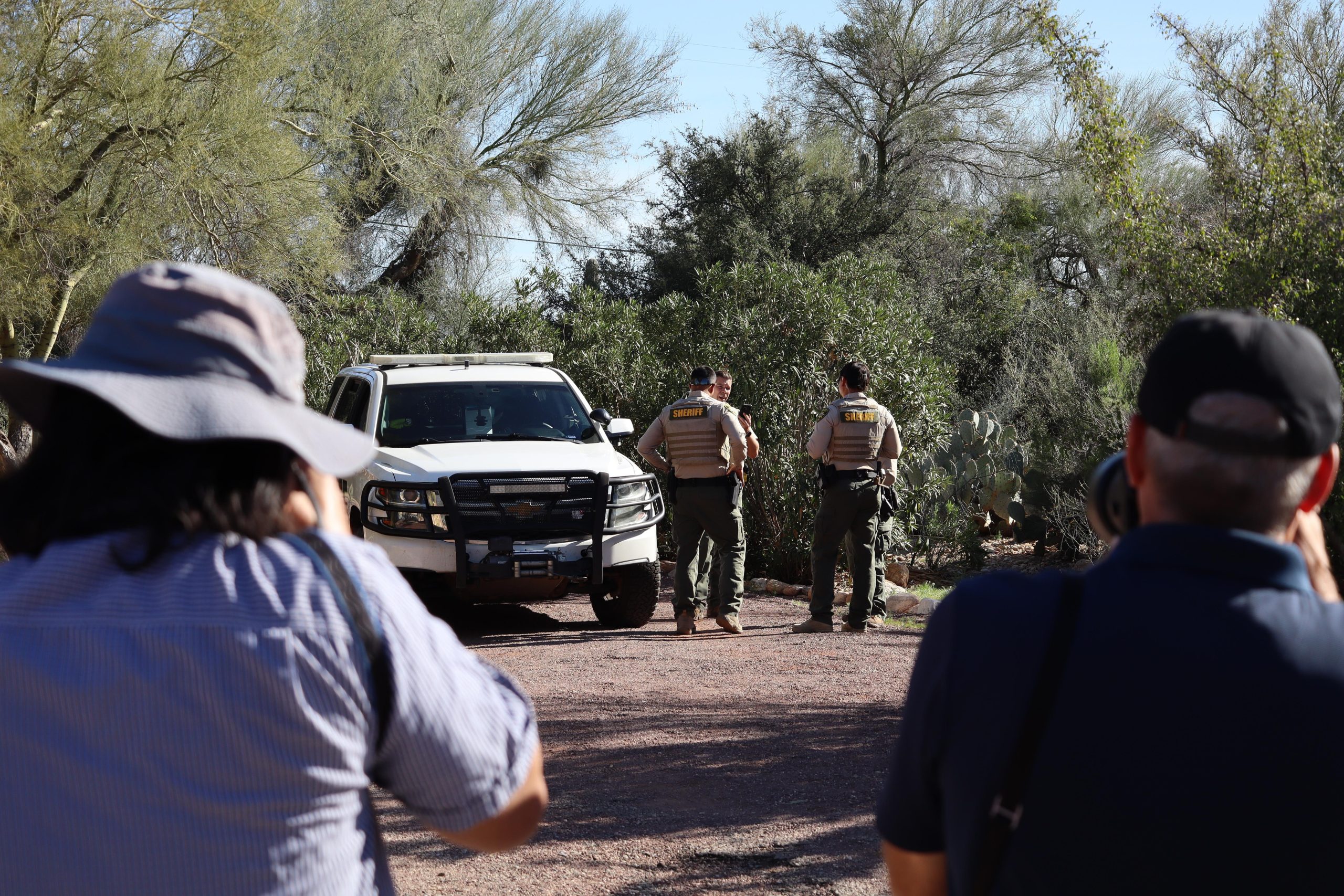Photographers take images of sheriff’s deputies outside the home of...